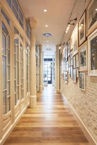 a hallway in a building with paintings on the walls at Hotel Pulitzer Barcelona in Barcelona