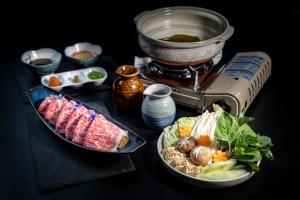 ein Tisch mit zwei Tellern Essen und einem Grill in der Unterkunft Onsen at Moncham in Chiang Mai