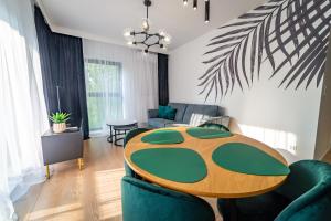 uma sala de estar com mesa e cadeiras em Lake Rental Spacerowa em Mikolajki