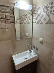 La salle de bains est pourvue d'un lavabo et d'un miroir. dans l'établissement Amarandos Studios Village Bliss, à Fodele