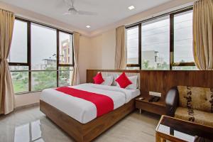 1 dormitorio con cama, sofá y ventanas en Super Capital O Hotel C Tara en Shirdi