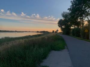 a road next to a body of water with a lake at Domek Letniskowy Wojtek in Gdańsk