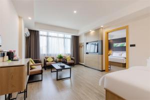 a hotel room with a bed and a living room at Thank Inn Chain Hotel Guangdong Qingyuan Fogang County 106 National Road in Qingyuan
