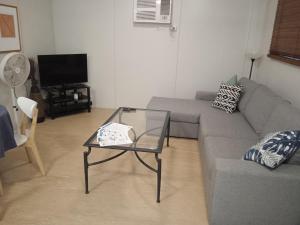 a living room with a couch and a glass table at Family Friendly in Howard Springs