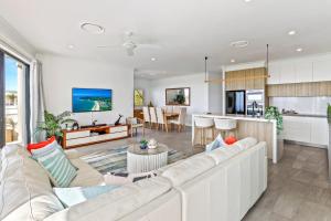 ein Wohnzimmer mit einem weißen Sofa und einer Küche in der Unterkunft Penthouse luxe, Sunrise Beach in Sunrise Beach
