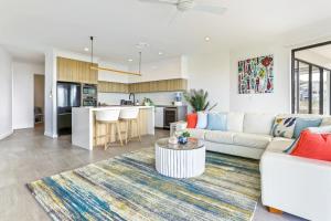 ein Wohnzimmer mit einem weißen Sofa und einer Küche in der Unterkunft Penthouse luxe, Sunrise Beach in Sunrise Beach