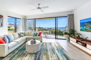 ein Wohnzimmer mit einem Sofa und einem Tisch in der Unterkunft Penthouse luxe, Sunrise Beach in Sunrise Beach