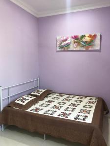 een bed in een slaapkamer met twee schilderijen aan de muur bij D'Pantai Homestay Kuala Sg. Baru in Melaka