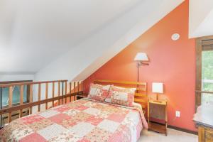 a bedroom with a bed with an orange wall at Manitou Lodge 9 by Alpine Lodging Telluride in Telluride