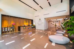 a lobby with a waiting area with chairs and a counter at Wholesome Hotel in Taipei