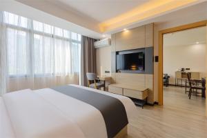 a hotel room with a large bed and a television at Thank Inn Chain Hotel Guangdong Qingyuan Fogang County 106 National Road in Qingyuan