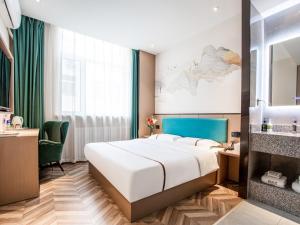 a bedroom with a bed and a desk and a sink at Thank Inn Plus Cangzhou Weiming Road Huabei Commercial Building in Cangzhou