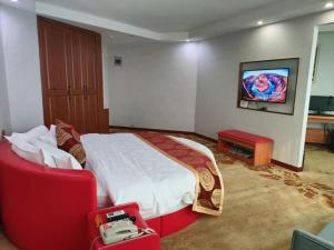 a bedroom with a large bed and a red chair at Thank Inn Plus Hotel Henan Luoyan Yanshi Luosheng Building in Yanshi