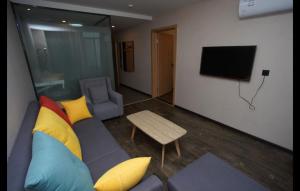 a living room with a couch and a tv at Thank Inn Chain Hotel Anyang Tangyin County Anyang Kindergarten in Anyang