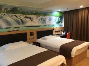 ein Hotelzimmer mit 2 Betten und einem Gemälde an der Wand in der Unterkunft Thank Inn Plus Hotel International Resort in Huinan