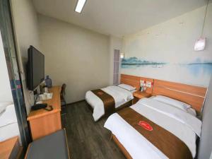 a hotel room with two beds and a flat screen tv at Thank Inn Chain Hotel Gansu Tianshui Taian Bus Station in Tianshui