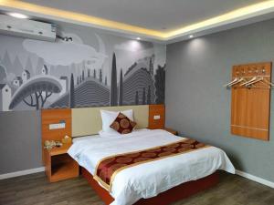 ein Schlafzimmer mit einem großen Bett und einem Gemälde an der Wand in der Unterkunft Thank Inn Plus Hotel Henan Luoyan Yanshi Luosheng Building in Yanshi