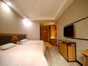 een hotelkamer met 2 bedden en een flatscreen-tv bij Up And In Shanxi Taiyuan University of Finance and Economics South Campus in Taiyuan