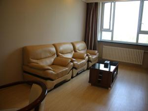 a living room with a couch and a coffee table at Thank Inn Chain Hotel Heilongjiang qiqihar Longsha District Middle Hospital High-Speed Railway South Station in Qiqihar
