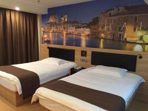 two beds in a hotel room with a painting on the wall at Thank Inn Plus Hotel International Resort in Nanhui