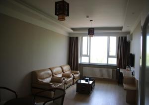 a living room with a couch and a table at Thank Inn Chain Hotel Heilongjiang qiqihar Longsha District Middle Hospital High-Speed Railway South Station in Qiqihar