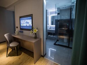 a room with a desk with a television and a chair at Thank Inn Plus Cangzhou Weiming Road Huabei Commercial Building in Cangzhou