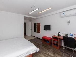 1 dormitorio con 1 cama, escritorio y TV en Thank Inn Chain Hotel Anhui Bengbu South Railway Station en Bengbu