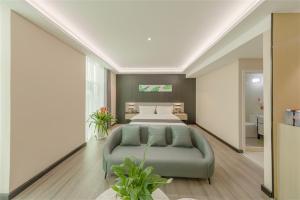 - une chambre avec un lit et un canapé dans l'établissement Thank Inn Chain Hotel Lanshan District Yitang, à Linyi