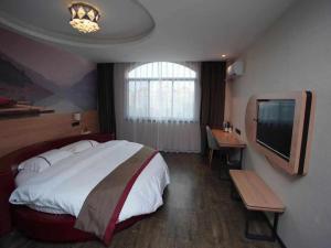 um quarto com uma cama grande e uma televisão em Thank Inn Chain Hotel Anyang Tangyin County Anyang Kindergarten em Anyang