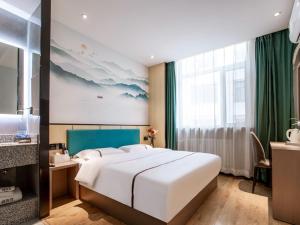 a bedroom with a large white bed and a window at Thank Inn Plus Cangzhou Weiming Road Huabei Commercial Building in Cangzhou