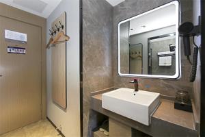 a bathroom with a white sink and a mirror at Thank Inn Chain Hotel Shanxi Yangquan Yu County West Xiushui Street in Yu