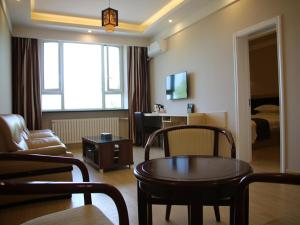 a living room with a couch and a table in a room at Thank Inn Chain Hotel Heilongjiang qiqihar Longsha District Middle Hospital High-Speed Railway South Station in Qiqihar
