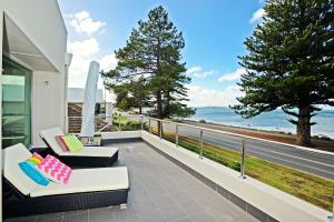 a balcony with two chairs and a view of the ocean at Luxury and Beachfront on Franklin in Encounter Bay