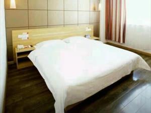 een slaapkamer met een groot wit bed in een kamer bij Thank Inn Chain Hotel Henan Luoyang Longmen Avenue Guanlin Road in Luoyang
