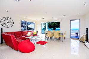 a living room with a red couch and a table at Luxury and Beachfront on Franklin in Encounter Bay