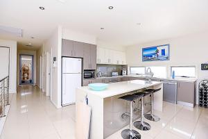 a large kitchen with a white counter and appliances at Luxury and Beachfront on Franklin in Encounter Bay