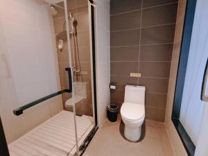 a small bathroom with a toilet and a shower at Thank Inn Plus Hotel Mianyang Normal University in Mianyang