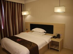 a hotel room with a bed and a table with a phone at Thank Inn Chain Hotel Heilongjiang qiqihar Longsha District Middle Hospital High-Speed Railway South Station in Qiqihar