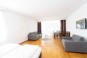 a living room with a bed and a couch and chairs at Bamberg Inn in Hallstadt