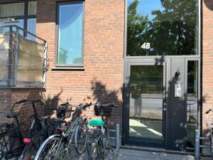 Copenhagen centre luxury apartment - Østerbro في كوبنهاغن: مجموعة من الدراجات متوقفة بجوار مبنى من الطوب