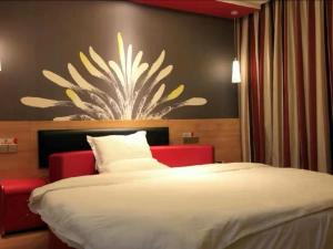 een slaapkamer met een groot bed met een bloem aan de muur bij Thank Inn Chain Hotel Henan Luoyang Longmen Avenue Guanlin Road in Luoyang