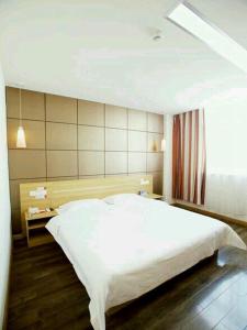 een slaapkamer met een groot wit bed en een raam bij Thank Inn Chain Hotel Henan Luoyang Longmen Avenue Guanlin Road in Luoyang