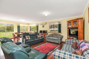 a living room with leather furniture and a tv at Holiday Close to the Beach Park Swimming Centre in Hayborough