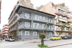 um edifício cinzento com varandas do lado de uma rua em MeYia studios em Tessalônica