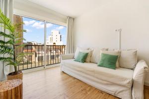 a living room with a white couch and a large window at Apartamento Welcs EMP 054 Cerca del Mar in Empuriabrava