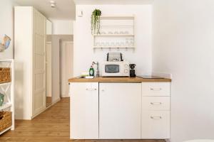 a kitchen with white cabinets and a microwave on a counter at Apartamento Welcs EMP 054 Cerca del Mar in Empuriabrava