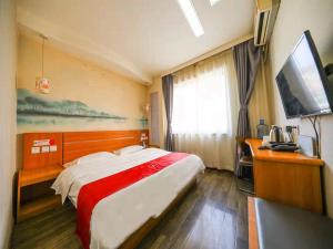 a hotel room with a large bed and a television at Thank Inn Chain Hotel Gansu Tianshui Taian Bus Station in Tianshui
