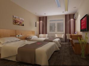 a hotel room with two beds and a desk at Thank Inn Chain Hotel Henan Luoyang Longmen Avenue Guanlin Road in Luoyang