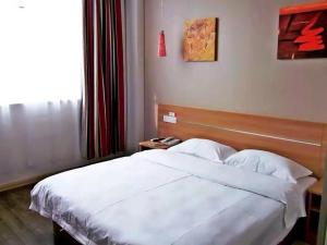 a bedroom with a white bed and a window at Thank Inn Chain Hotel Henan Luoyang Longmen Avenue Guanlin Road in Luoyang