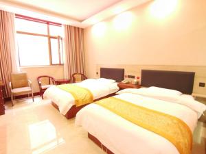 a hotel room with two beds and a window at JUN Hotels Shanxi Yuncheng Yongji Bus Station in Yuncheng